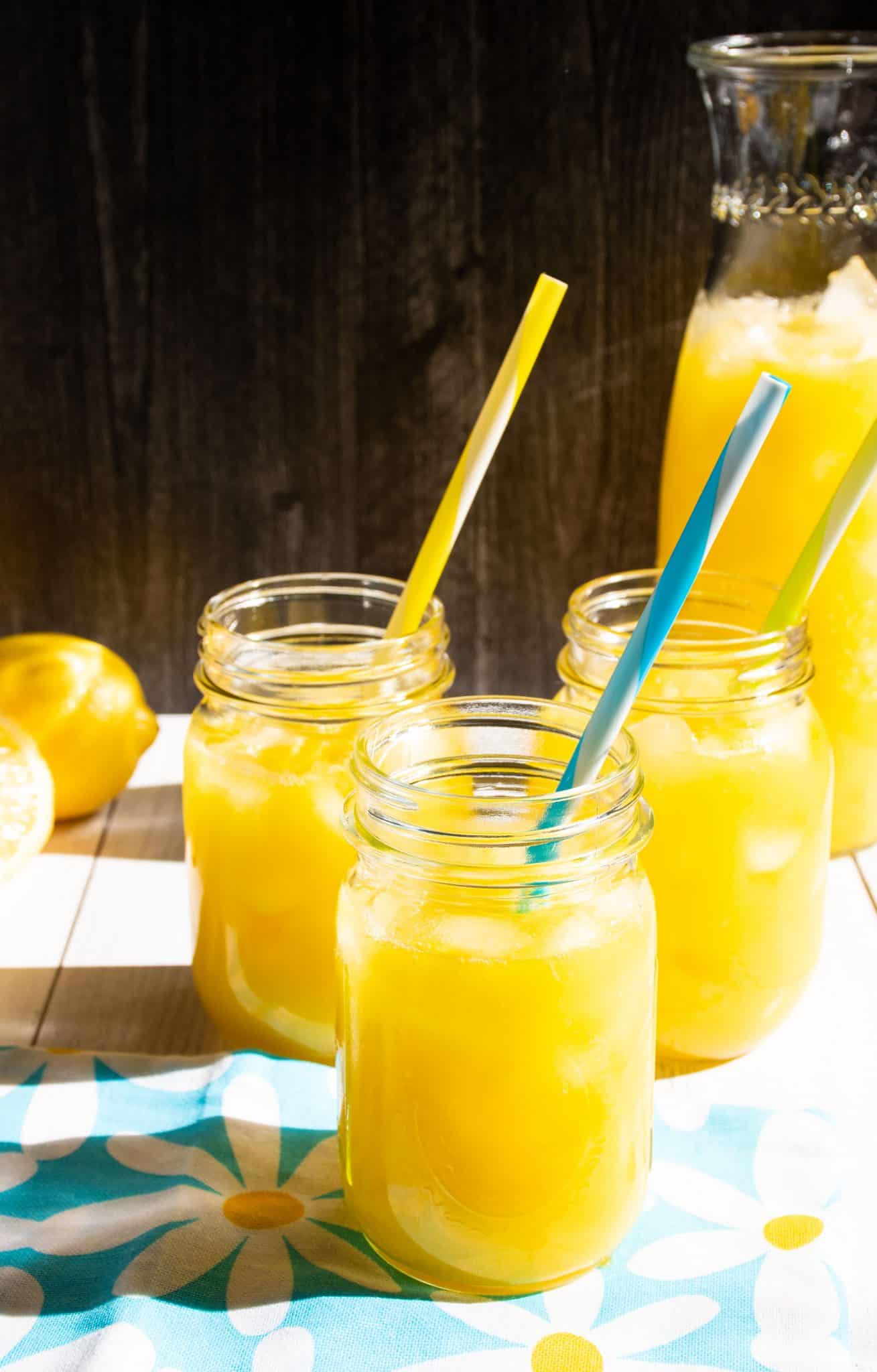 Three Mason jars with lemonade in them.