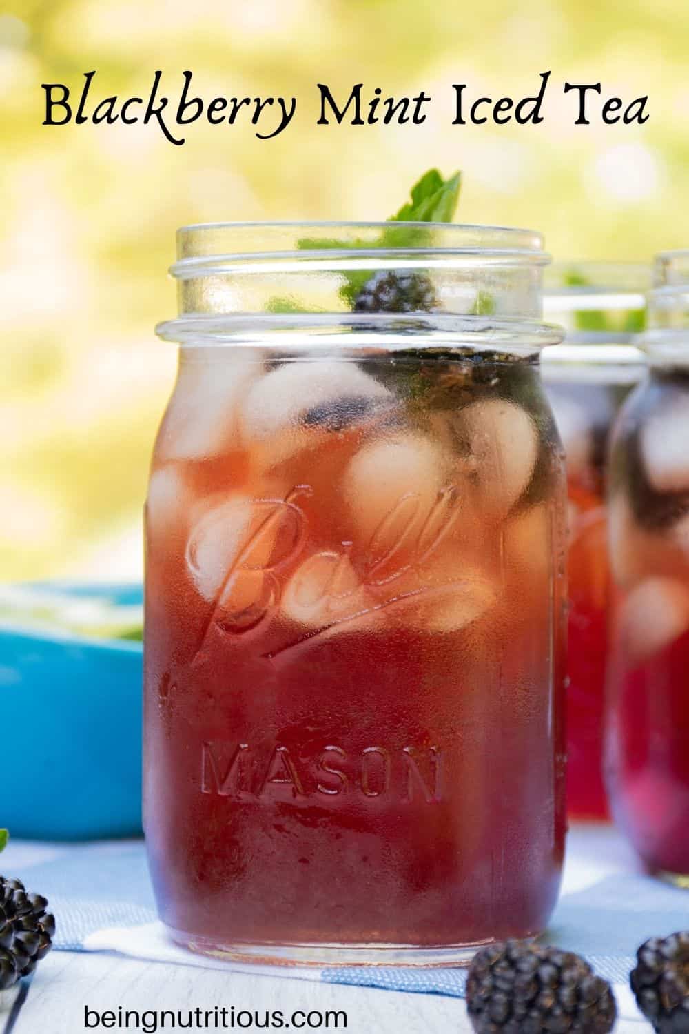Iced tea in Mason jars, with ice, blackberries, and mint. Text overlay: Blackberry Mint Iced Tea.