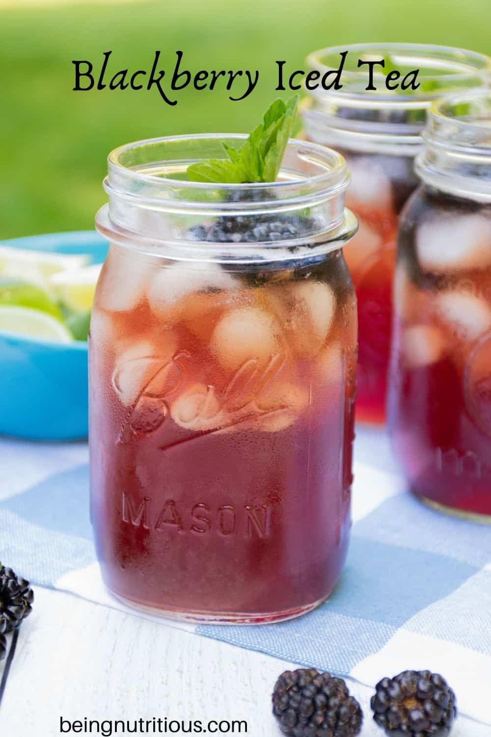 Iced tea in Mason jars, with ice, blackberries, and mint. Text overlay: Blackberry Iced Tea.