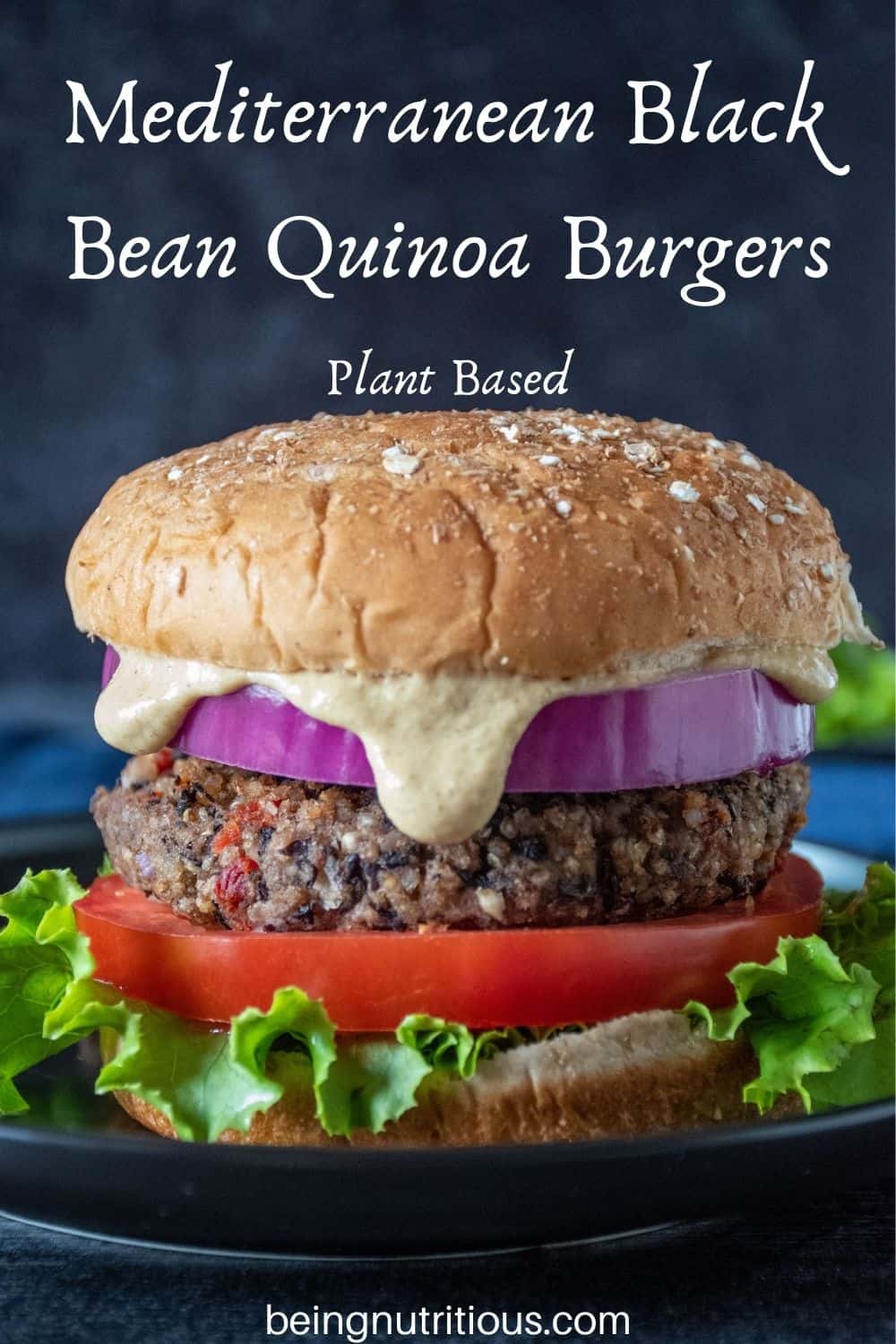 Bean burger on a bun, with onions, tomatoes, lettuce and sauce dripping out. Text overlay: Mediterranean Black Bean Quinoa Burgers; Plant Based.