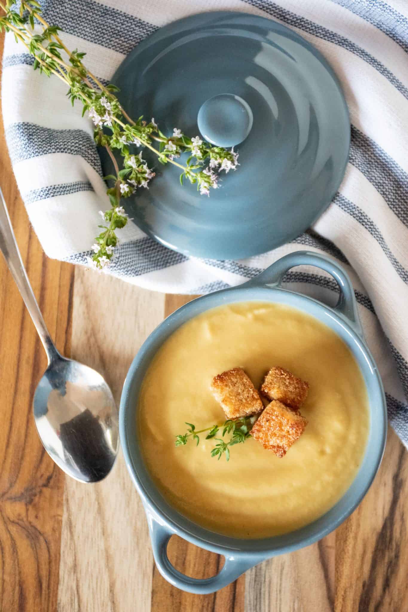 Small bowl of soup with croutons and fresh thyme.
