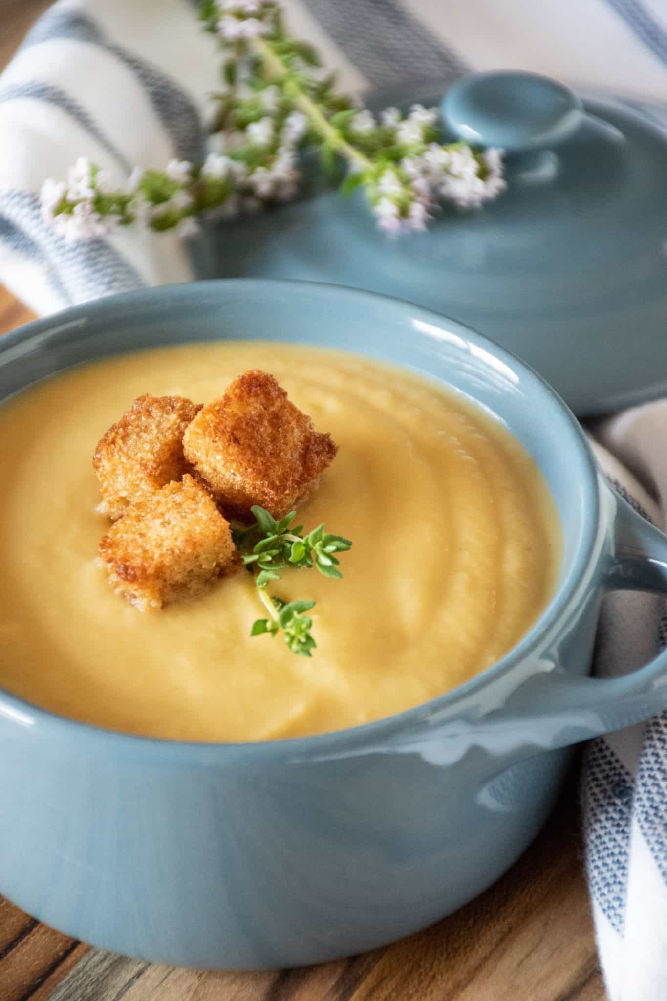 Small bowl of soup with croutons and fresh thyme.