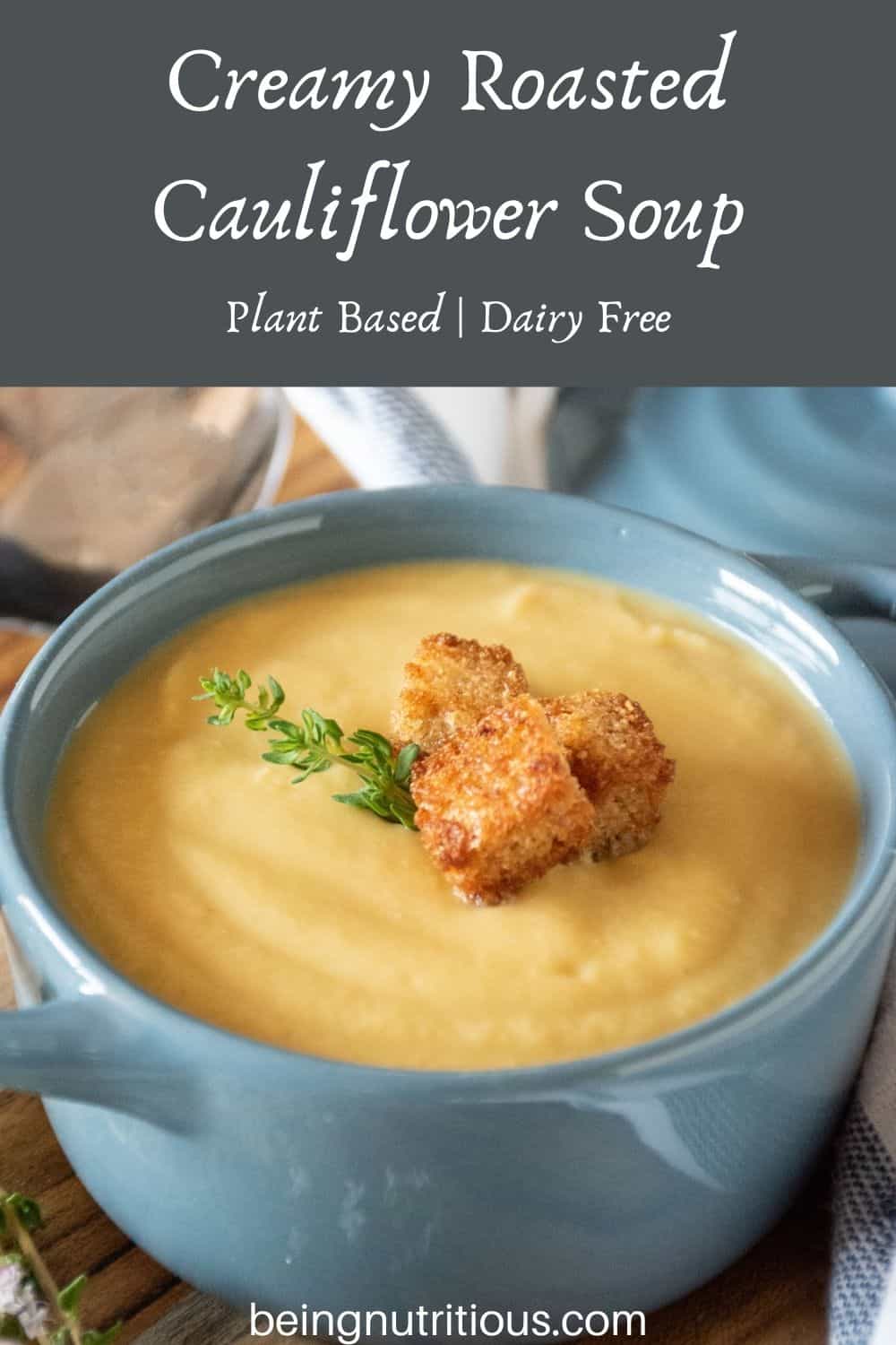 Small bowl of soup with croutons and fresh thyme. Text overlay: Creamy Roasted Cauliflower Soup; plant based, dairy free.