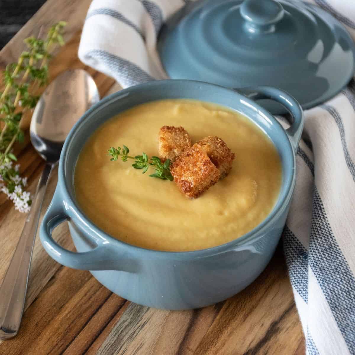 Small bowl of soup with croutons and fresh thyme.