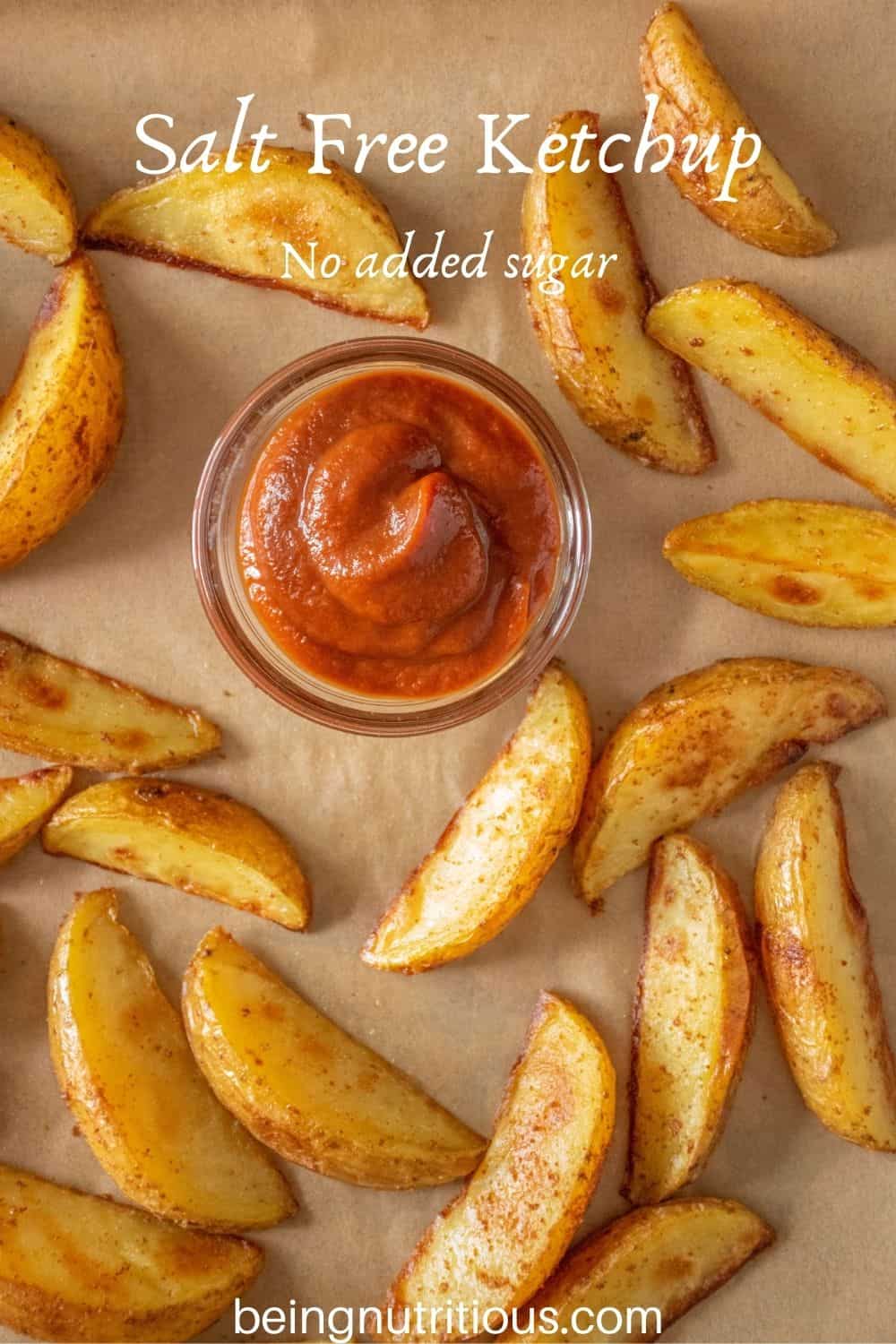 Small glass dish of ketchup, surrounded by baked potato wedges. Text overlay: Salt Free Ketchup; no added sugar.