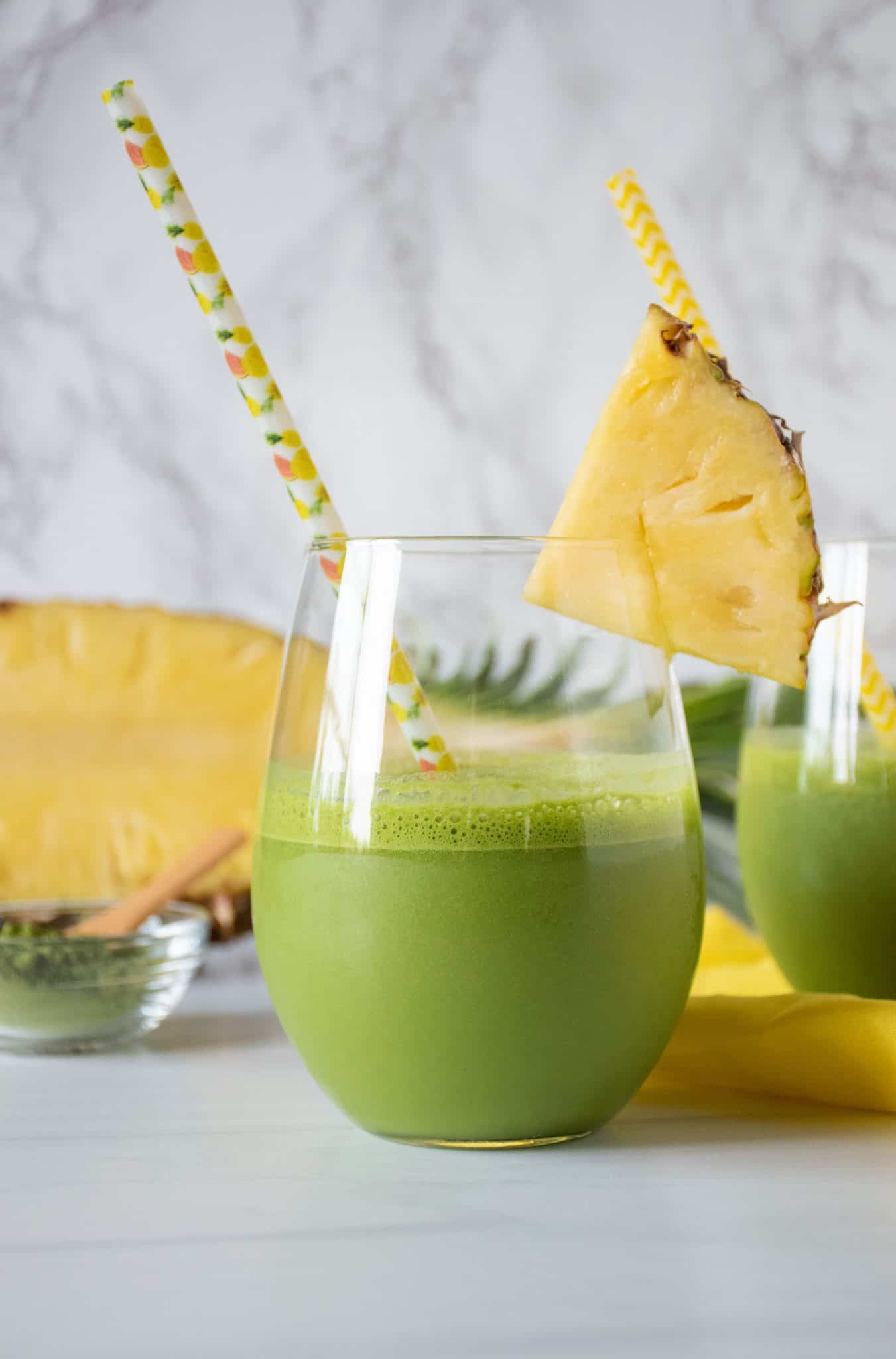 Glass of iced matcha drink, garnished with a pineapple slice.