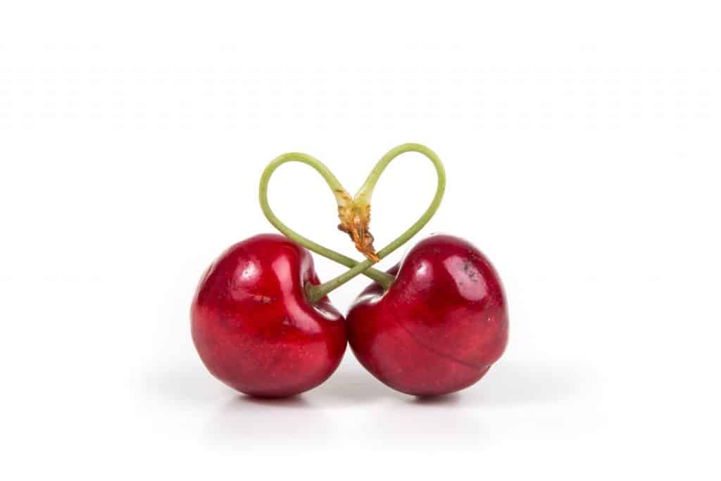 Two cherries, with stems arranged in the shape of a heart
