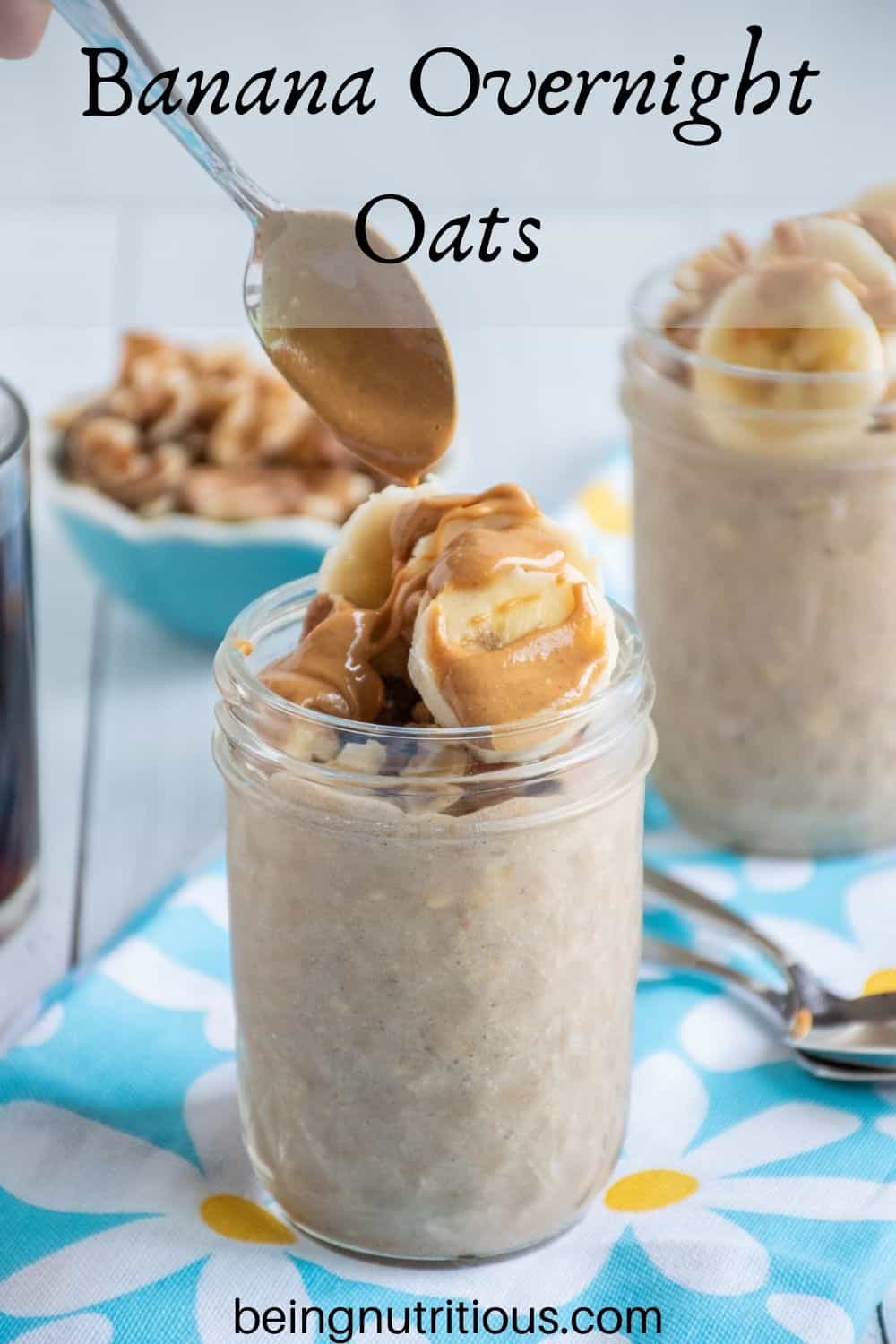 Small mason jar of oatmeal with walnuts and banana slices on top, being drizzled with peanut butter. Text overlay: Banana Overnight Oats.