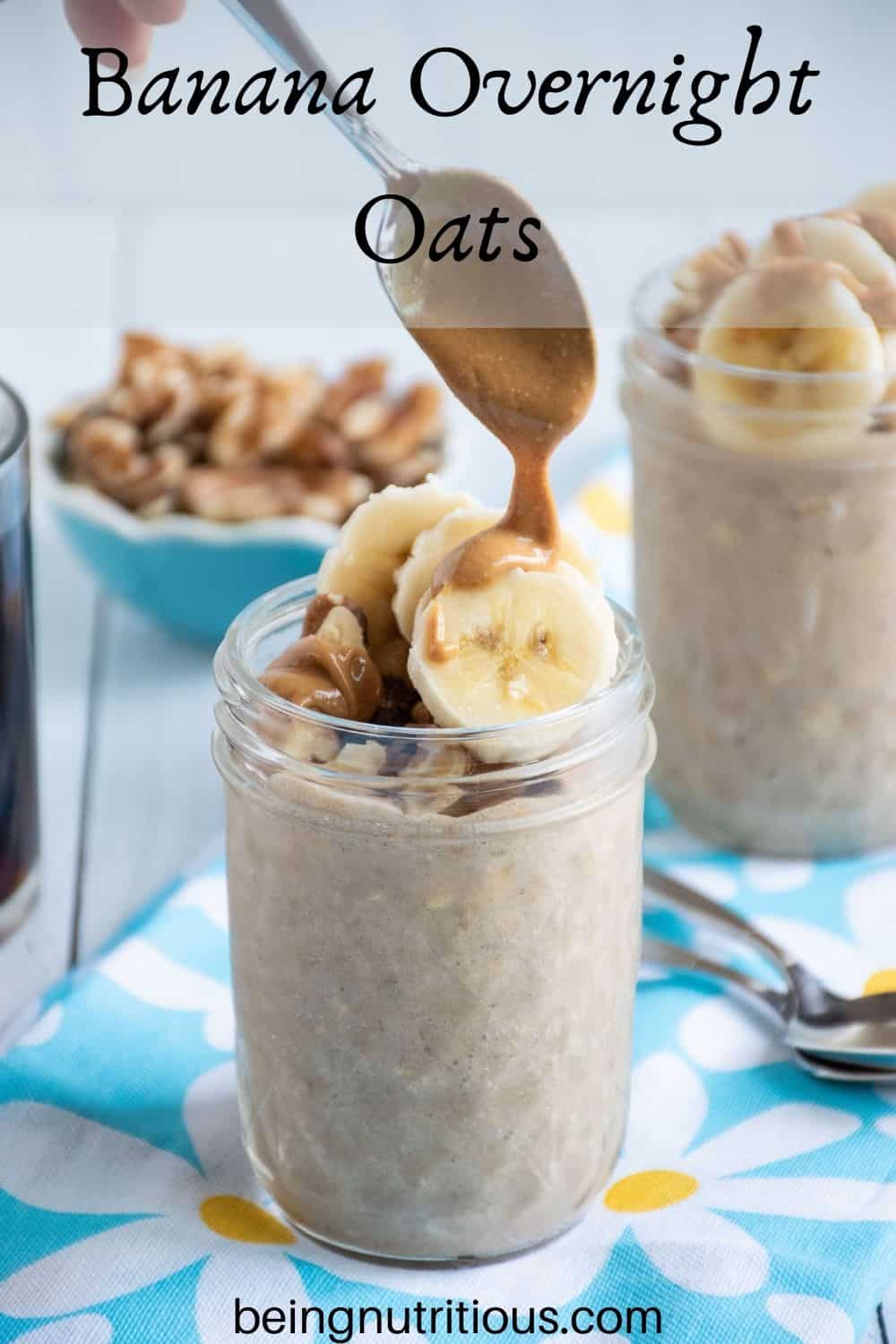 Small mason jar of oatmeal with walnuts and banana slices on top, being drizzled with peanut butter. Text overlay: Banana Overnight Oats.