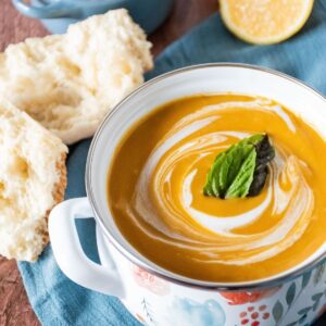 Small crock of creamy soup, garnished with basil leaves.