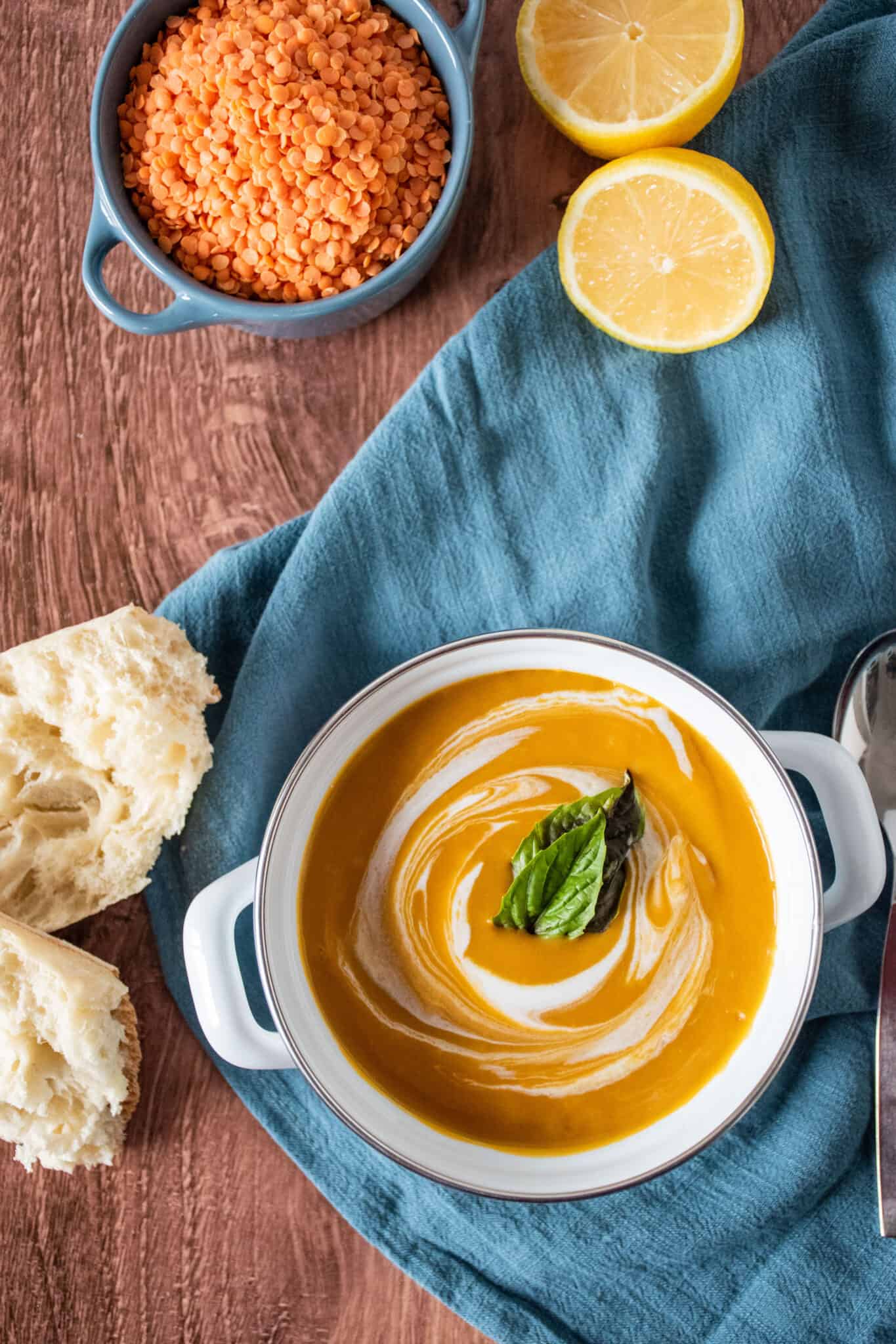 Overhead shot of small crock of creamy soup, garnished with basil leaves.