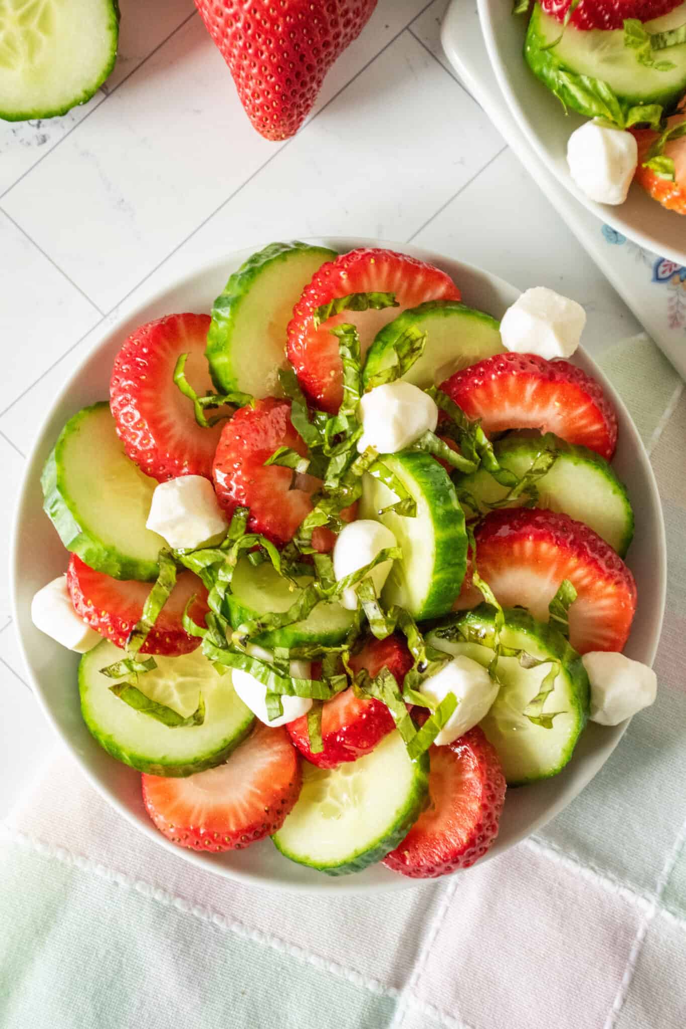 Strawberry cucumber salad on a small plate, from overhead