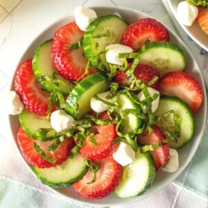 Strawberry cucumber salad on a small plate, from overhead