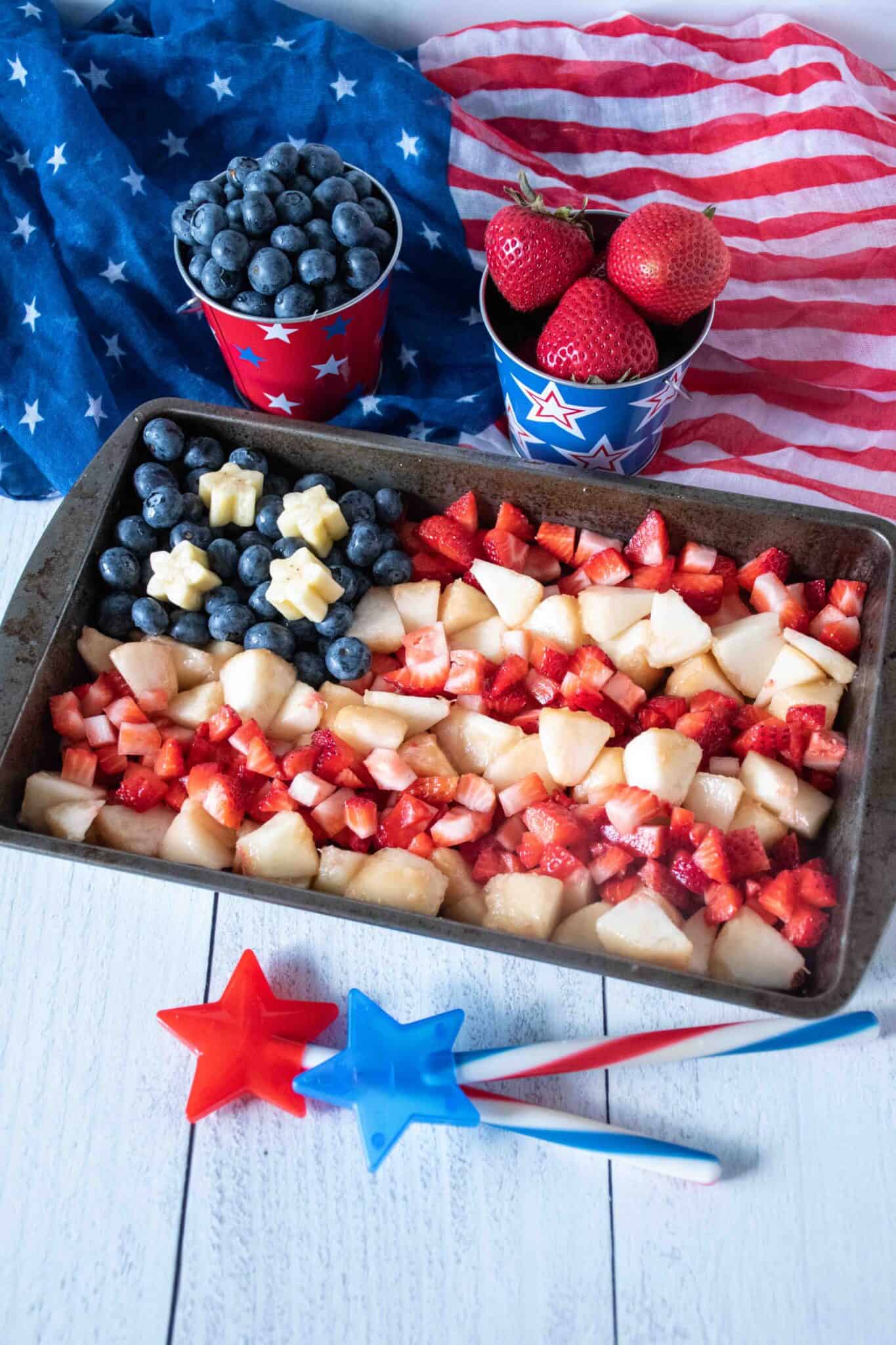 Small tray with strawberries, blueberries, and white peaches arranged in the shape of an American flag.