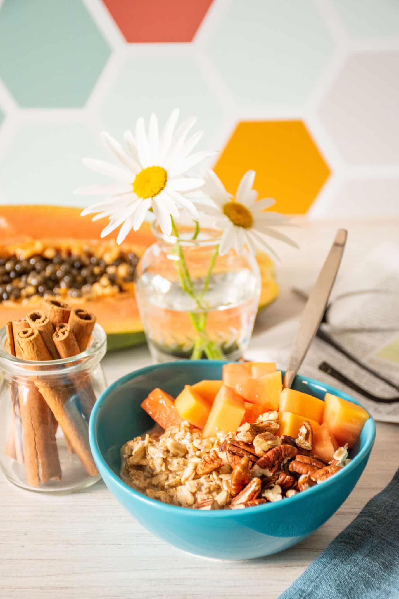 Small bowl of oats, with chopped pecans and papaya.