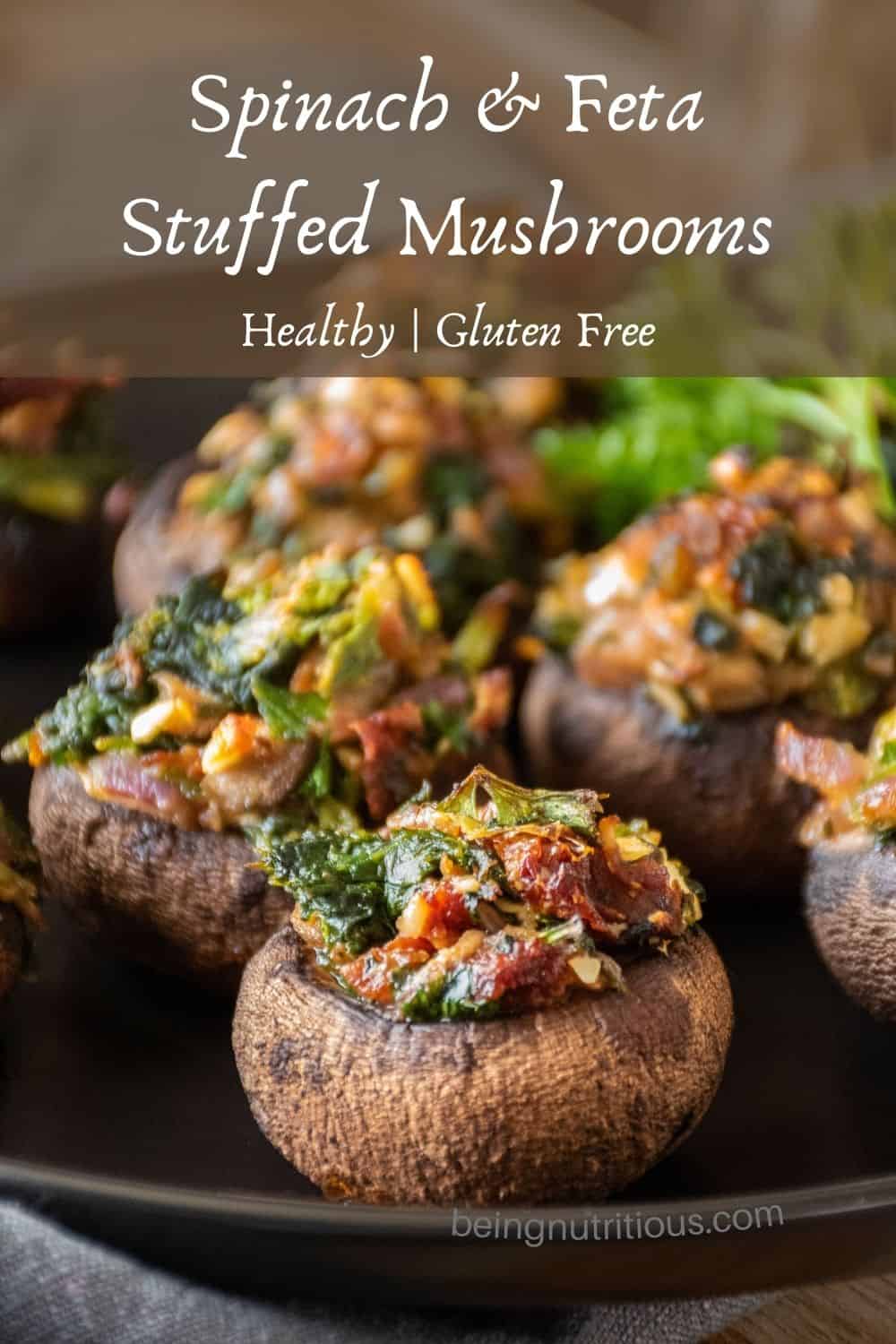 Close up of a plate of stuffed mushrooms. Text overlay: Spinach & Feta Stuffed Mushrooms; Healthy, Gluten Free.