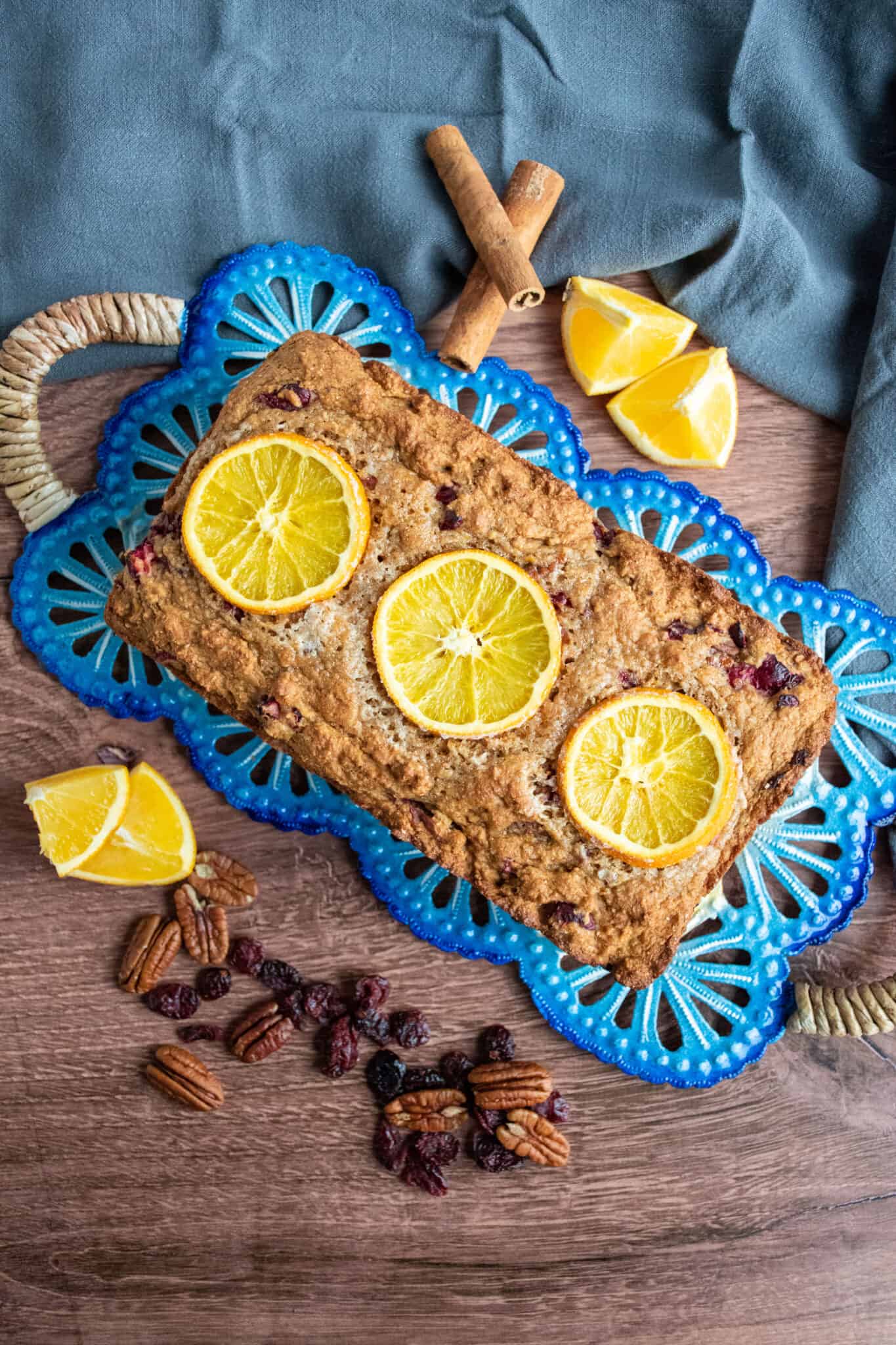 Overhead shot of a loaf of quick bread studded with candied oranges.