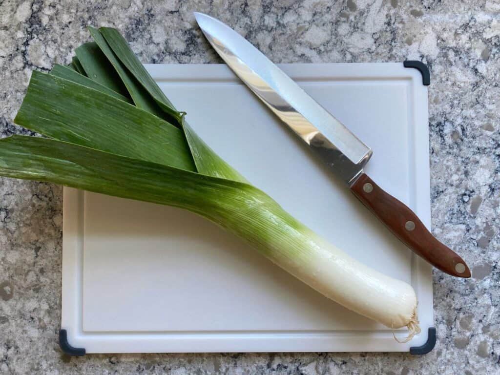 A leek on a cutting board.