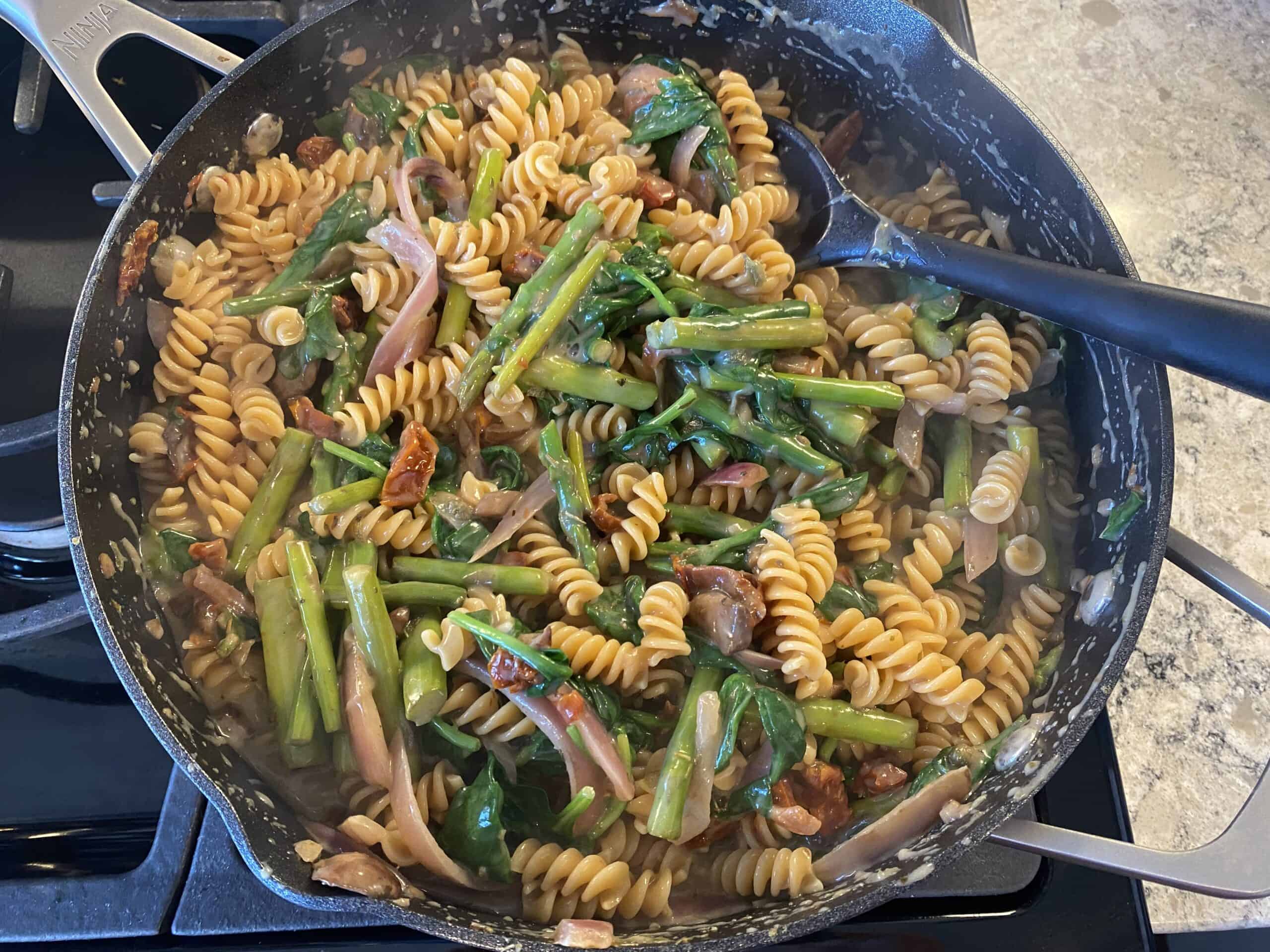 Creamy pasta dish in a large sauté pan.