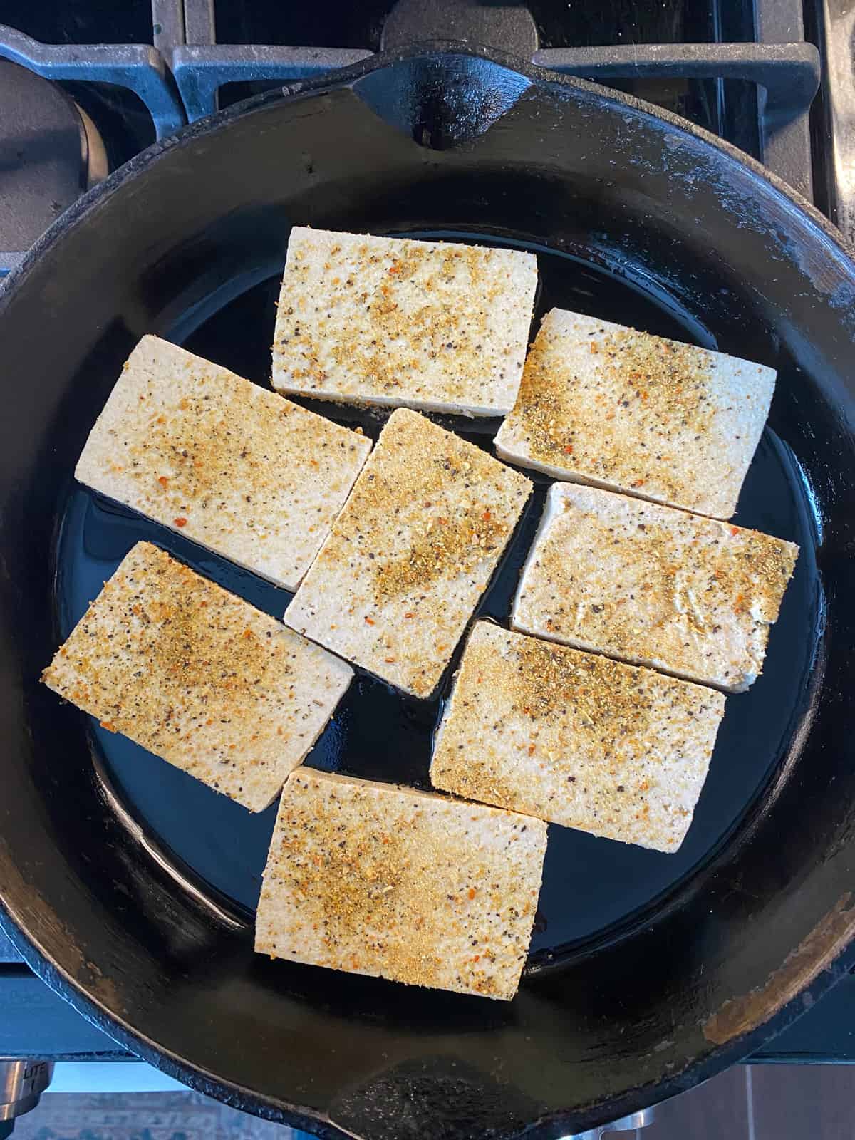 Tofu added to a hot skillet.