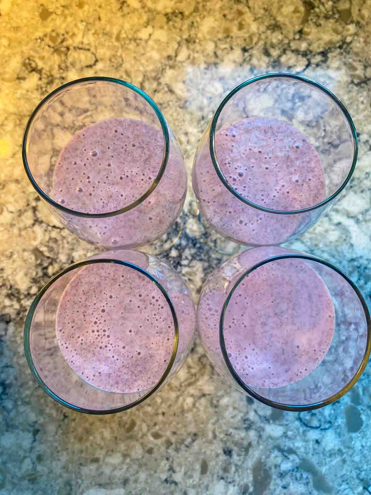 Overhead shot of 4 dessert glasses with strawberry pudding in them.