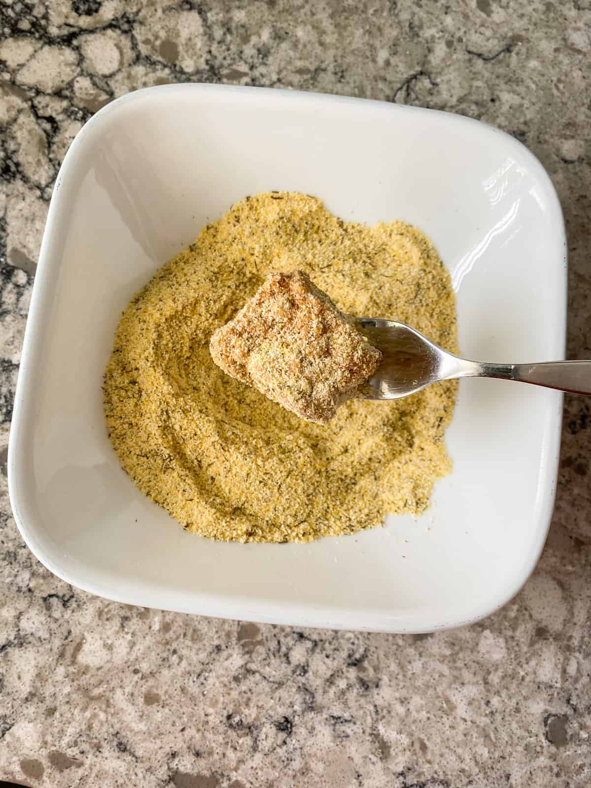 Tempeh square dredged in cornmeal breading.