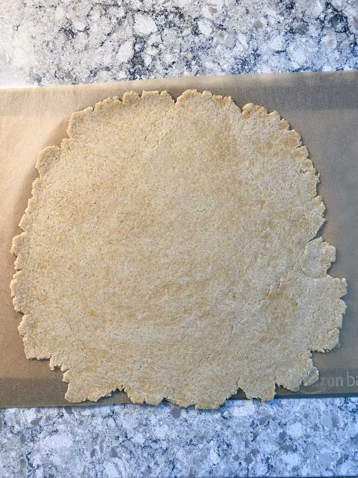 Dough rolled out into a rough circle.