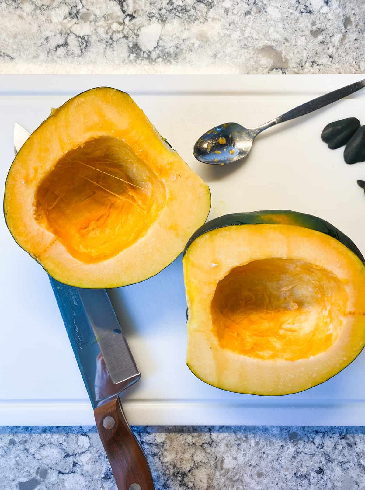 An acorn squash, halved, with seeds removed.
