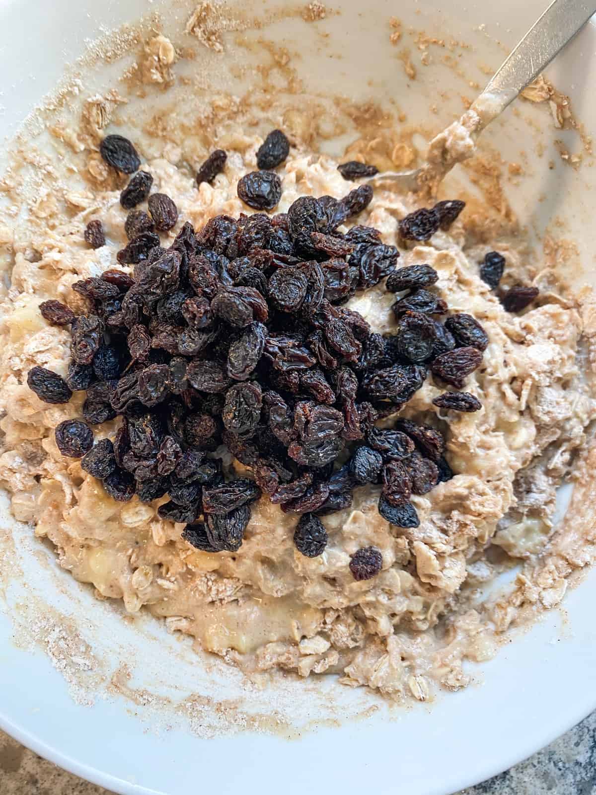 Muffin batter with raisins added, before mixing in.