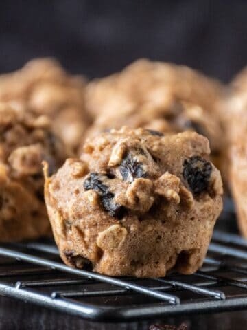Close up of a mini muffin on a cooling rack with the rest of the muffins in the background.