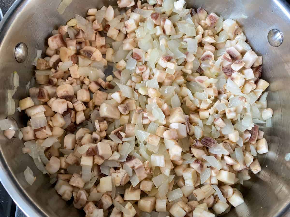 Diced mushrooms added to the pan of sautéed onions.