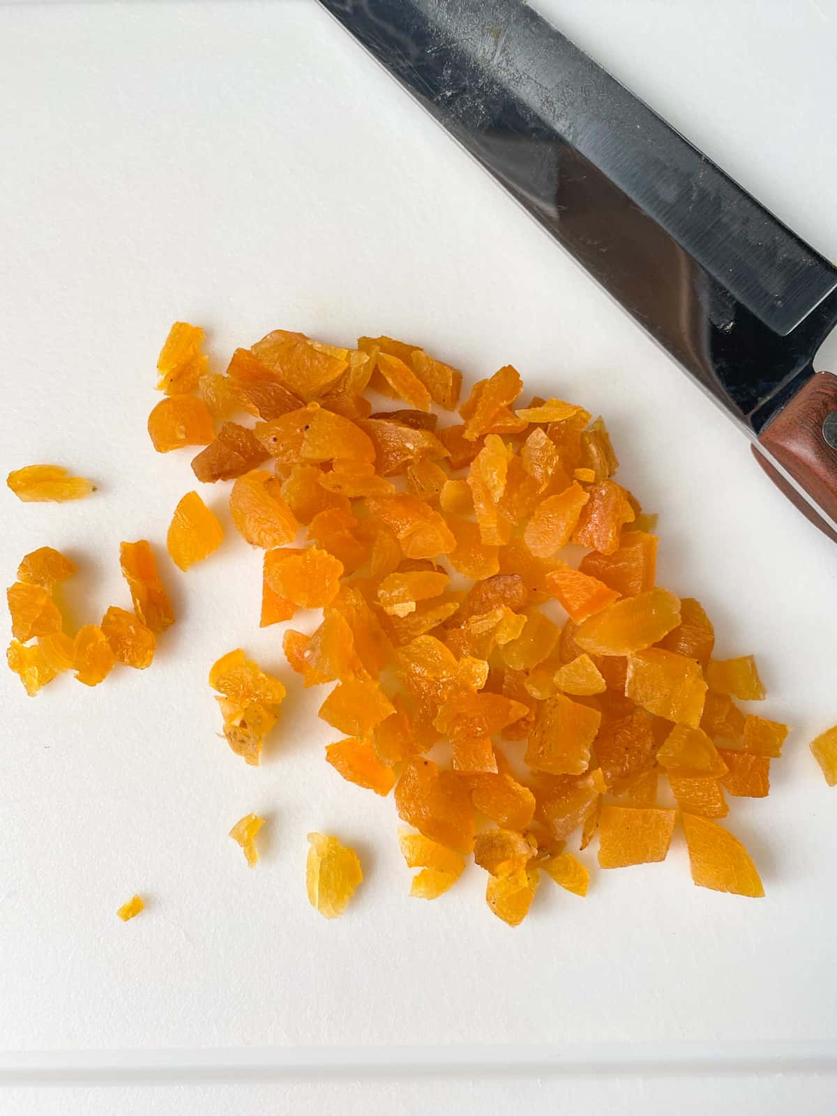 Chopped dried apricots on a cutting board.