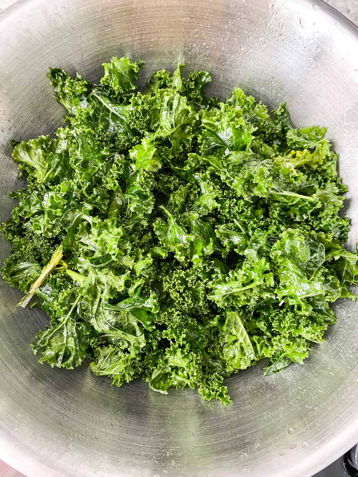 Massaged kale in a large metal bowl.