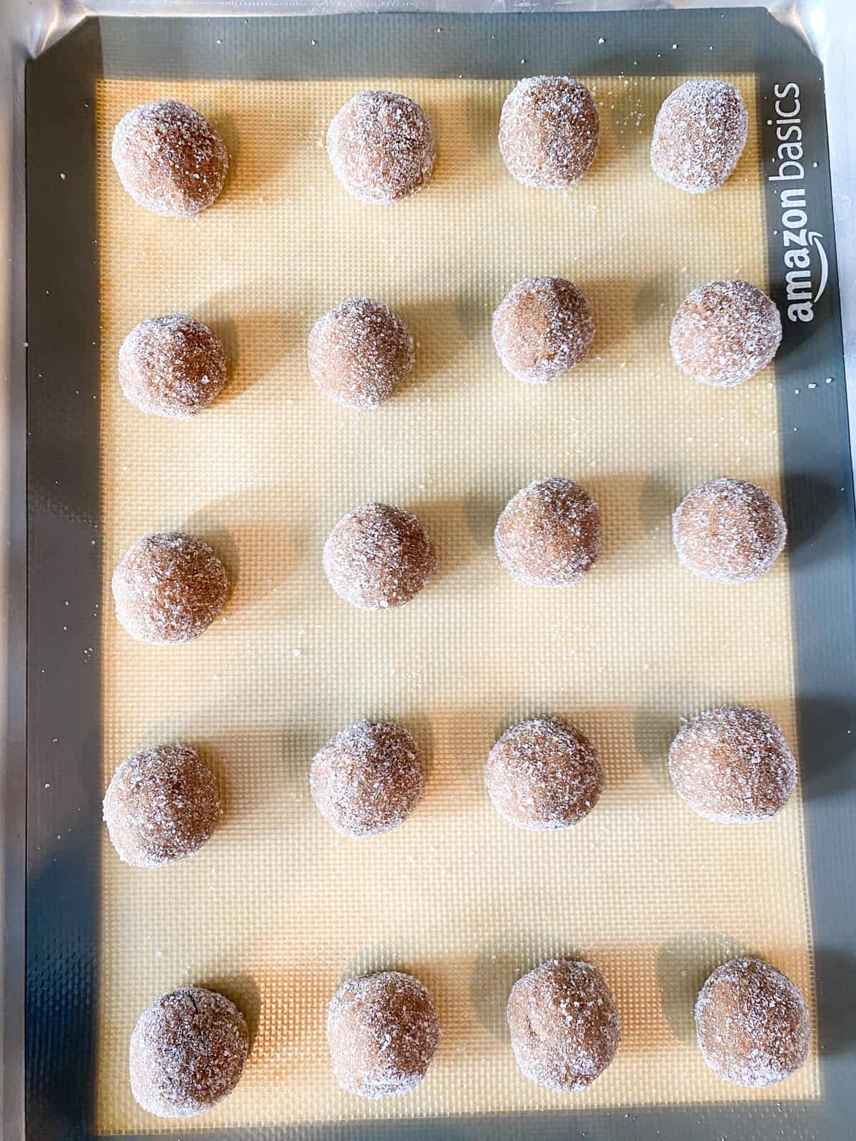 Cookie dough rolled into balls, then rolled in sugar, and arranged 2 inches apart on a cookie sheet.