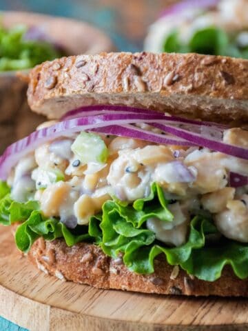 Chickpea salad on a sandwich, with lettuce and red onion.