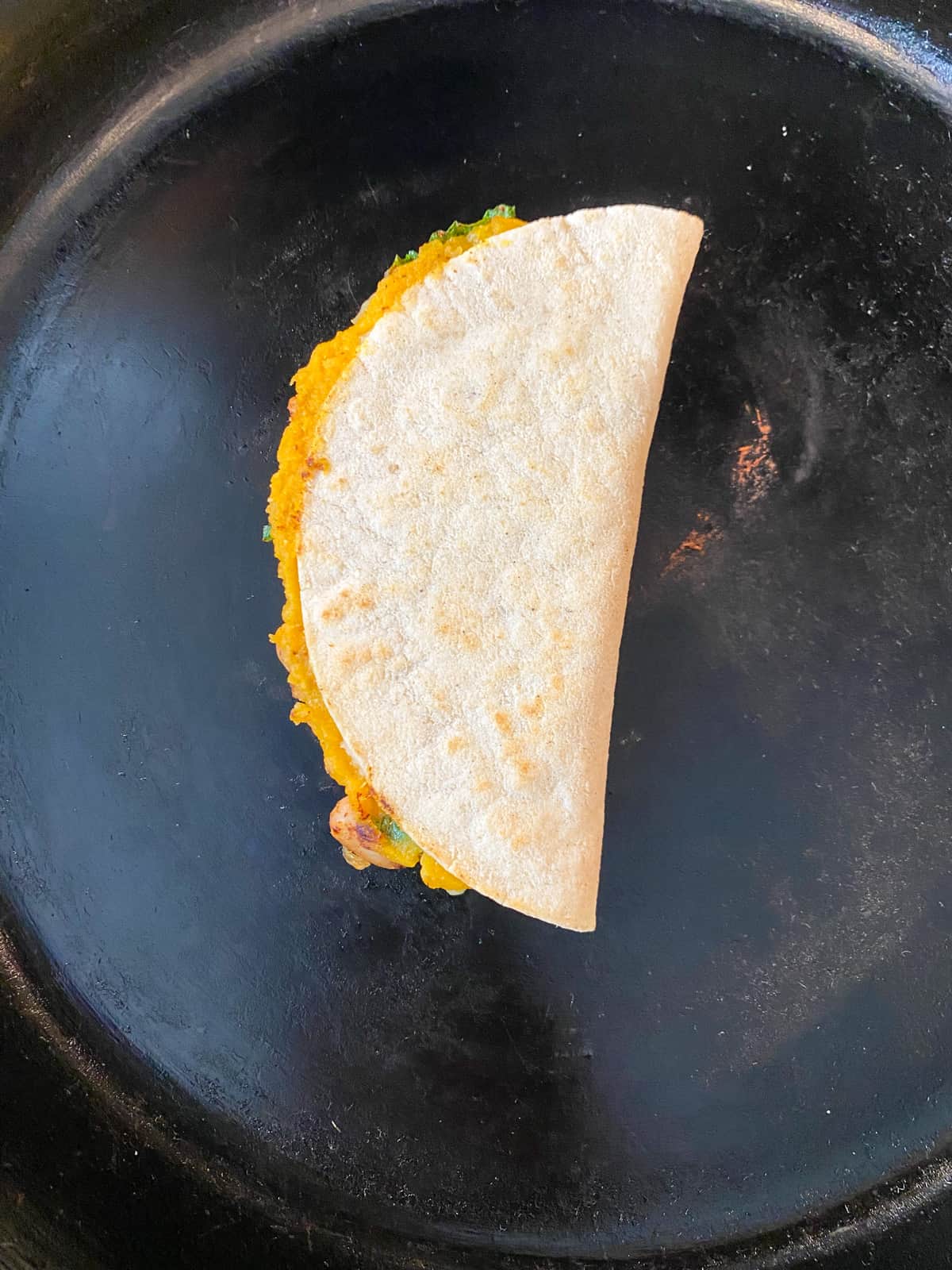 Quesadilla in a skillet, cooking.