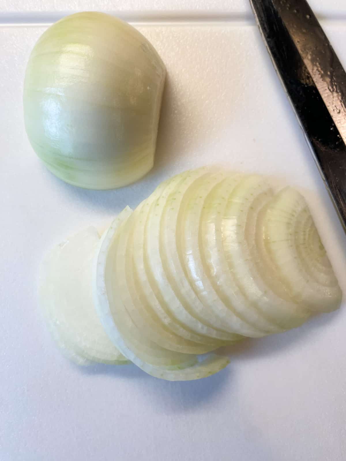 Onion, sliced, on a cutting board.