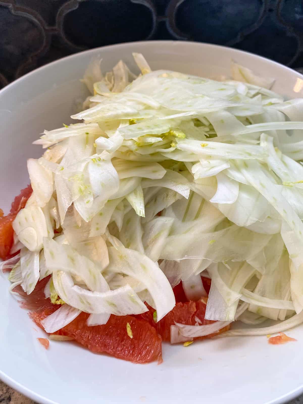 Fennel added to the bowl with the citrus segments.