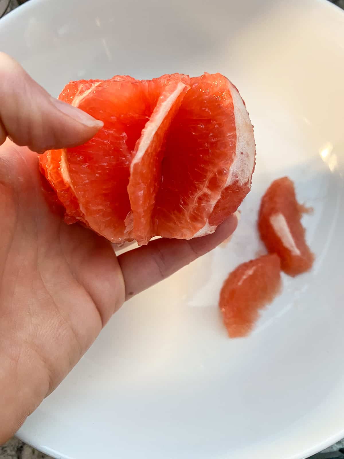Grapefruit with several segments cut out of it.