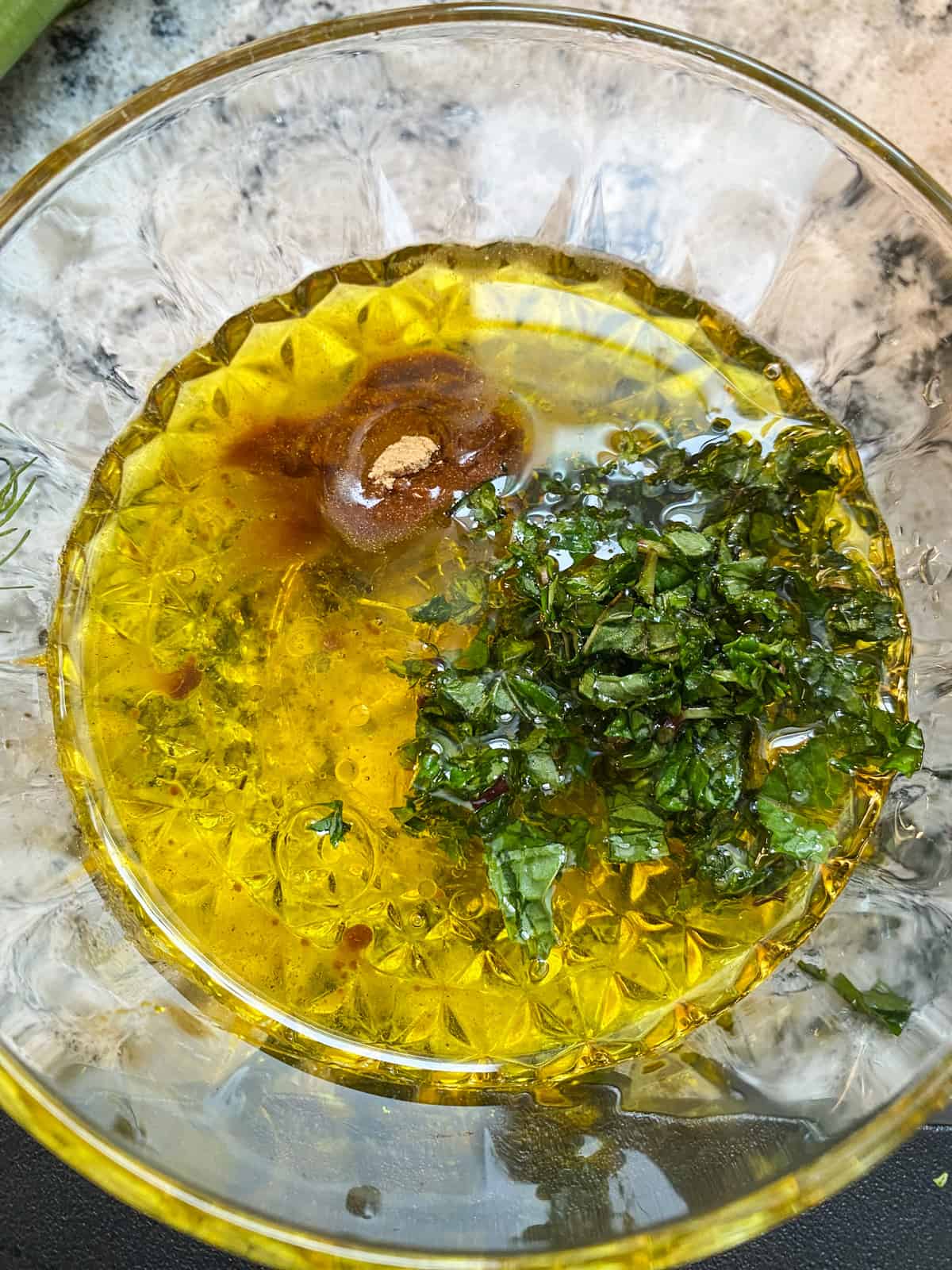 Salad dressing ingredients in a small glass bowl.