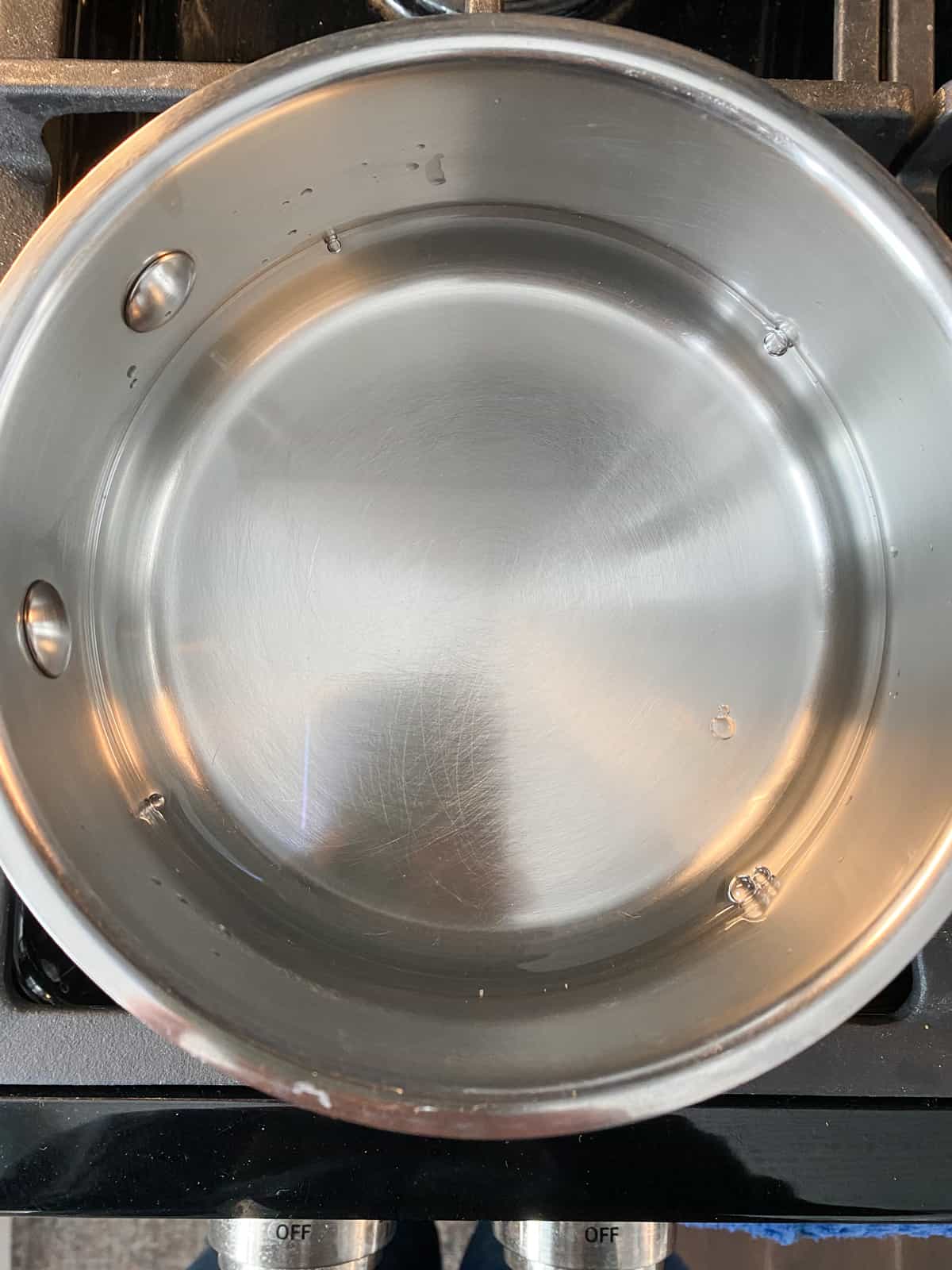 Water in a pot, on the stove.