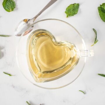 Tea in a heart shaped glass teacup.