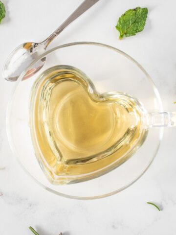 Tea in a heart shaped glass teacup.