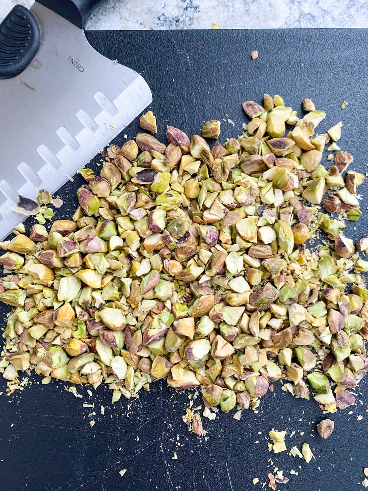 Chopped pistachios on a cutting board.