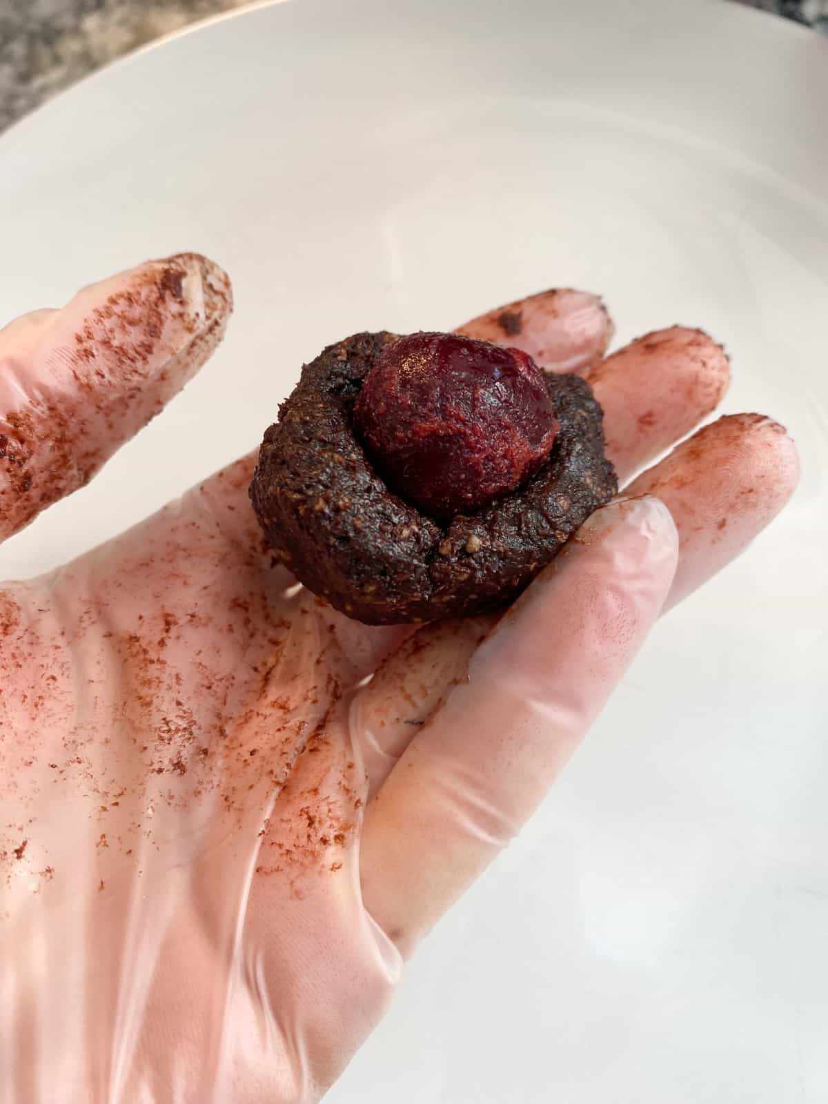 Frozen cherry placed in the middle of the bowl shaped dough.