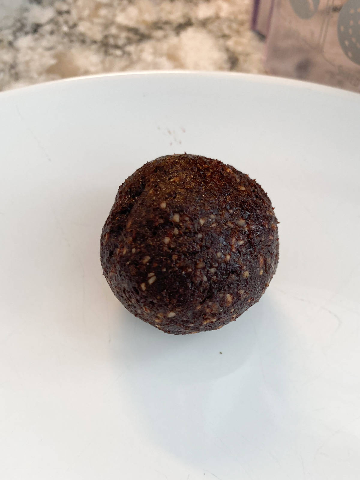 Truffle dough molded around the frozen cherry, with edges sealed to prevent the juices from leaking out.