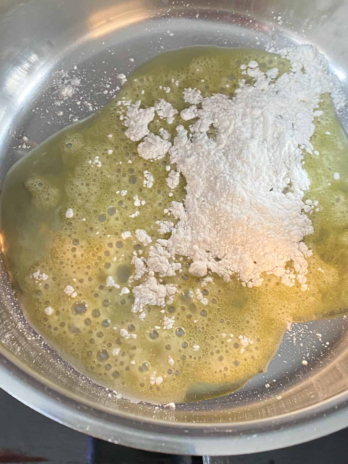 Flour sprinkled into a pan with heated oil.
