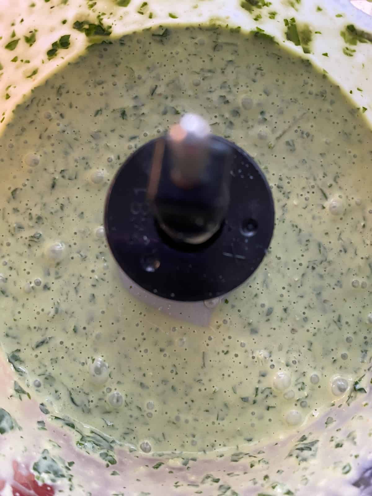Completely blended pesto sauce, in a food processor.