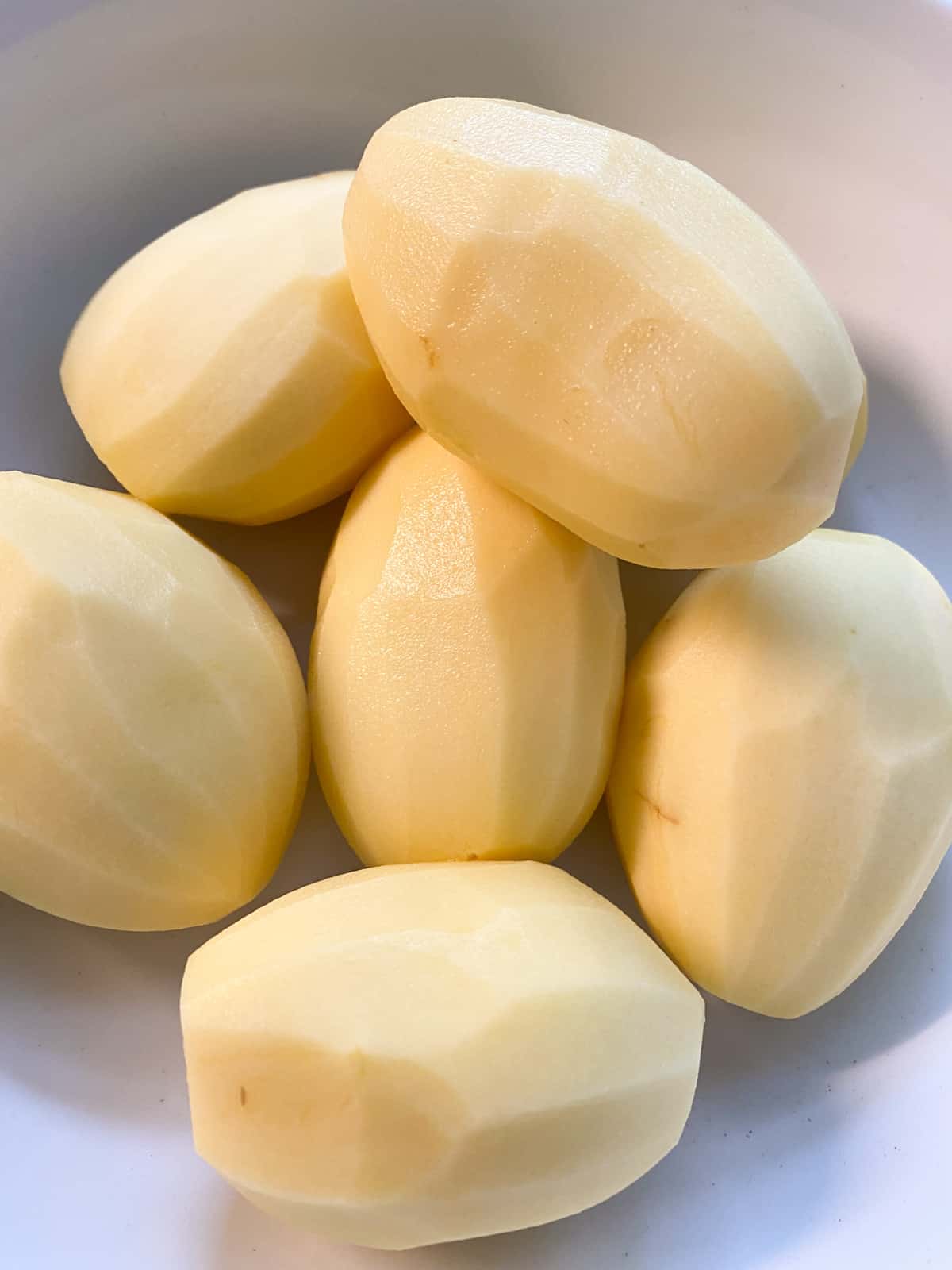 Peeled potatoes in a bowl.