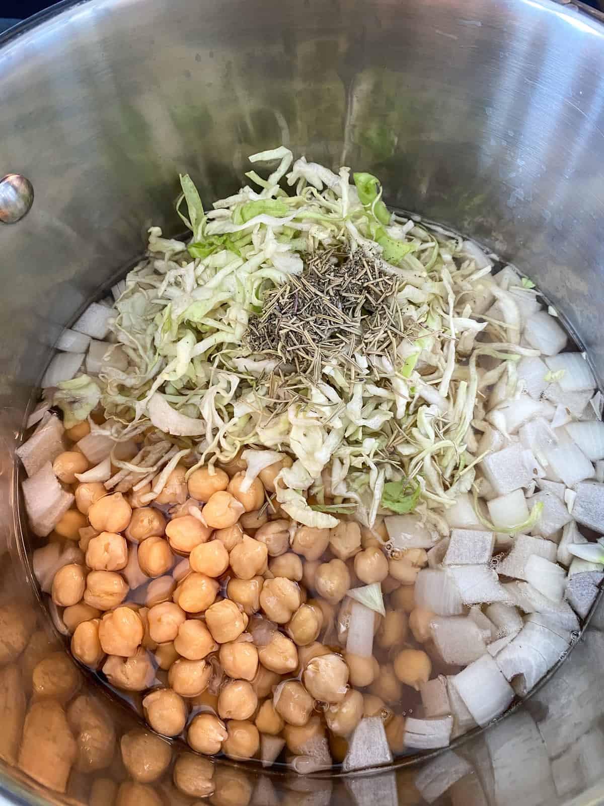 Dried herbs added to the stew in a large pot.